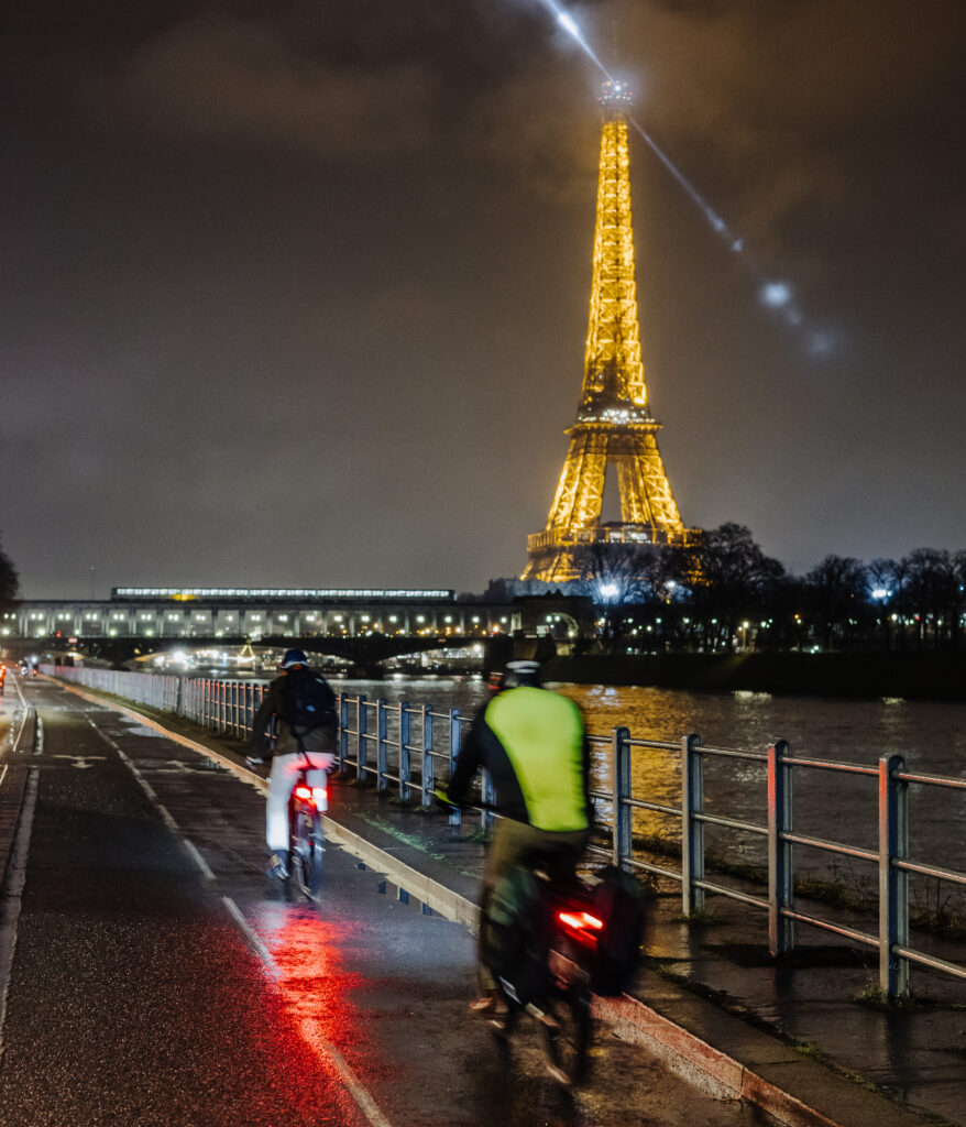 La Tour Eiffel illuminée et recouverte de brume et de nuages dans la soirée du 7 février 2024. Elle est photographiée depuis la piste cyclable bidirectionnelle de la voie George Pompidou longeant la seine dans le 16e arrondissement de Paris.